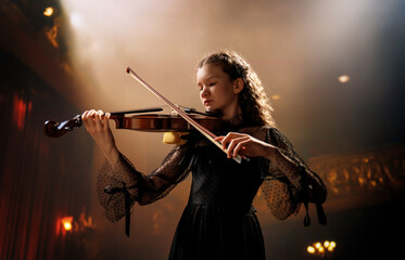 girl playing violin on stage