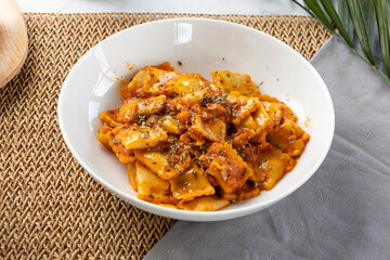 Ravioli pasta with tomato sauce and herbs