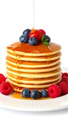 Stack of pancakes with syrup and berries
