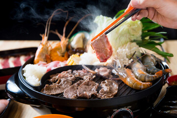 Raw beef slice for barbecue, meat are being cooked on stove or Japanese style yakiniku.