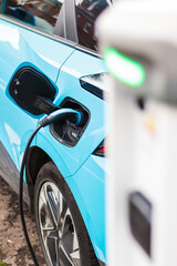 Blue Electric Car Charging at Station