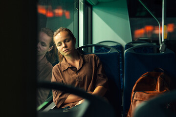 Tired urban commuter woman napping on bus at night. © Barillo_Images