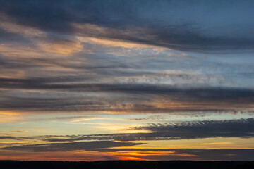 Vibrant sunset colors fill the sky over serene landscape creating a peaceful atmosphere during twilight in nature's embrace