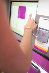 Person buying subway ticket from touchscreen kiosk