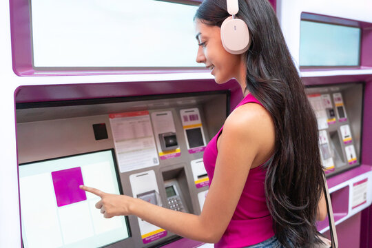 Young woman buying ticket at subway station