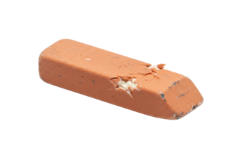 Orange rubber eraser with visible chew or bite marks, typically used for correcting pencil marks in school or office settings.
