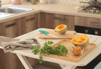 Pumpkin and parsley on wooden cutting board in kitchen. Healthy eating and food. Mediterranean diet. Modern interior.