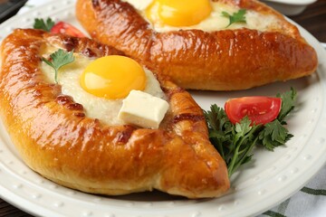 Tasty khachapuri with cheese and eggs on table, closeup