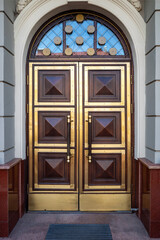 grand entrance adorned with intricate decorative elements, reflecting the clear blue sky.