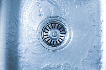 Water going down sink drain, top view © New Africa