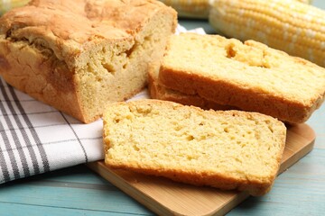 Freshly baked cornbread and cob on light blue wooden table, closeup