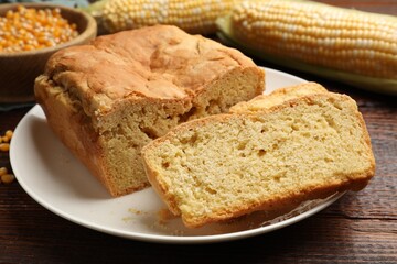 Freshly baked cornbread, cobs and seeds on wooden table, closeup