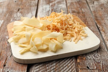 Dried shredded squid and shavings on color wooden table, closeup