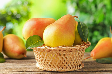 Fresh ripe pears on wooden table outdoors, closeup