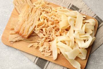 Tasty dried squid on grey table, top view