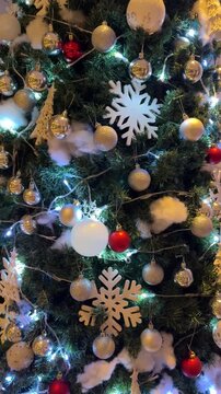 4k footage close up of lighted Christmas tree ornaments and decorations. Mistletoe, baubles, and bell with Interactive sparkling christmas twinkle lights or icicle lights.