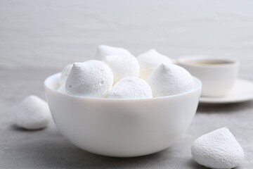 Yummy meringue cookies in bowl on grey table, closeup