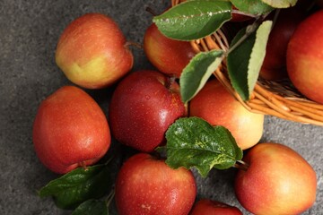 Fresh ripe apples in basket on grey table, flat lay