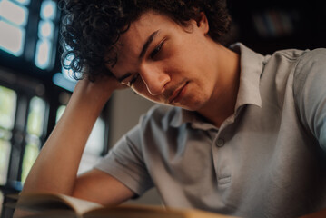 Focused student reading and studying with concentration in library