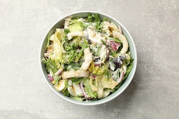 Tasty salad with squid rings, onion and eggs served on light grey table, top view