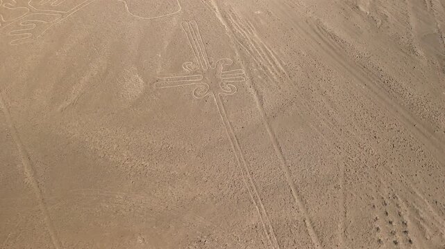 Aerial flyover shot of a massive ancient geoglyph one of the mysterious Nazca Lines etched into the desert plateau of Peru