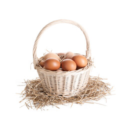 Chicken eggs in basket and nest isolated on white