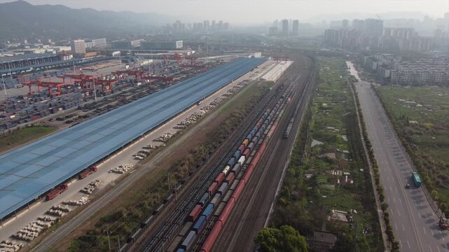 Aerial View of Railway Container Terminal and Freight Train Logistics Hub with Urban Skyline