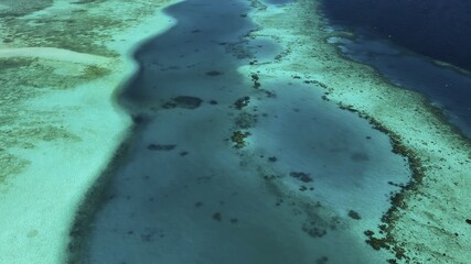 Aerial view of turquoise waters meeting sandy shores, creating a mesmerizing contrast of light and shadow, embodying the serene beauty of the Maldives, Maldives.