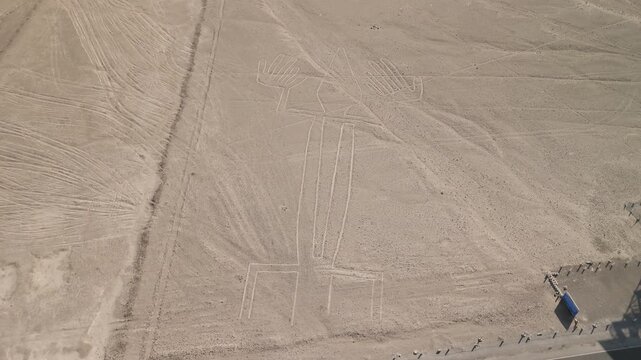 Aerial parallax shot revealing the complex lizard-shaped geoglyph at the Nazca Lines in Peru, showcasing the intricate ancient drawings etched in the desert sands under clear skies