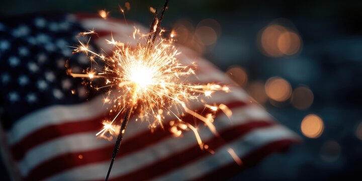 Celebrating freedom with a sparkler in hand near the American flag during a festive gathering at night