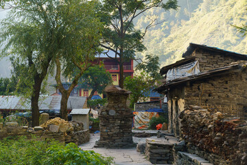 Stone village path with trees and mountains