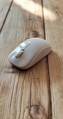 Sleek white mouse sits on a light-toned wood surface