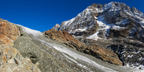Glacier tongue flowing over rugged mountains. View of the anun and langgletscher in Loetschental valley in Valais, Switzerland
