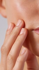 Skin care routine shows close-up of a person gently touching their cheek with clean hands