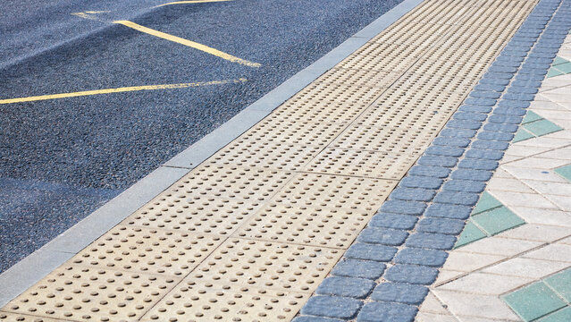 A detailed closeup view of a brick walkway positioned closely next to a road