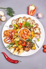 Top view of meat platter with pomegranate and veggies. Captures generosity and elegance.