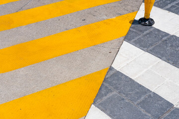 Urban pedestrian crossing with diagonal yellow stripes and grey pavement showing geometric patterns for corporate branding, design clarity and urban identity