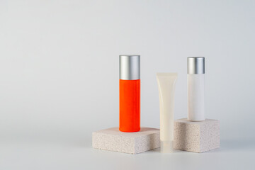 Cosmetic product in tube, bottle, lotion or serum with stylish props on white background. 