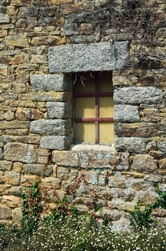 Detalle de ventana y pared de piedra de una casa tradicional de tejado de paja en Kerasco&euml;t, Breta&ntilde;a, Francia
