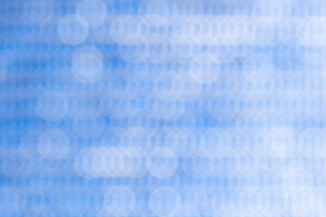 Abstract circular bokeh background, defocused dots on blue background.