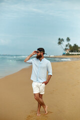 Portrait of handsome bearded man in shirt on the beach.