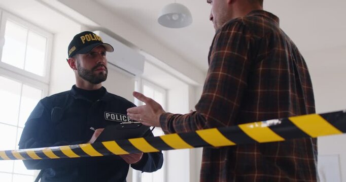 Policeman or detective gathers testimony from a witness and collects evidence for a report during a crime scene investigation. The focus is on ensuring safety and accurate documentation.