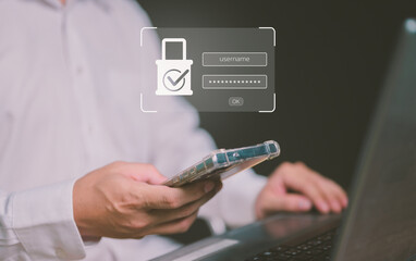 Cybersecurity concept. A businessman uses a smartphone and laptop for secure login with a username and password. Data protection, digital privacy, and network security with two-factor authentication.