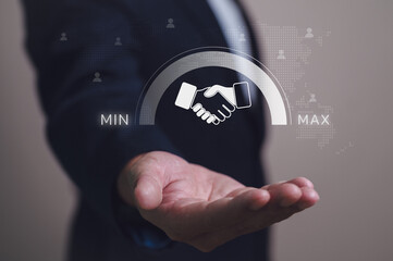 Business partnership and agreement concept. A businessman holds a handshake icon with a performance meter pointing to maximum for success. Global customer relationship management (CRM) and growth.