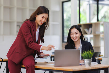 Businesswomen collaborating on laptop, discussing project plan