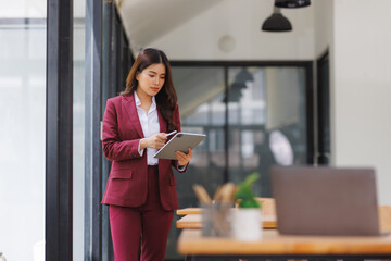 Young businesswoman using digital tablet in modern office