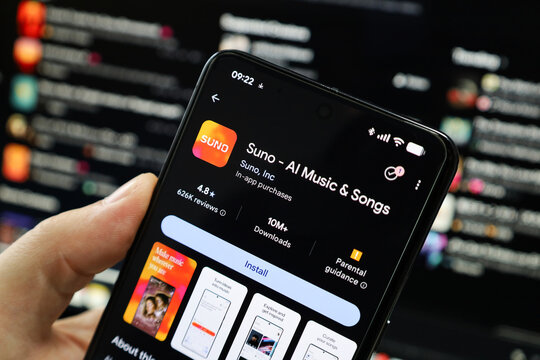 Hand holding cellphone with logo artificial intelligence company Suno AI Music & Songs app in front of business webpage. Focus on phone display