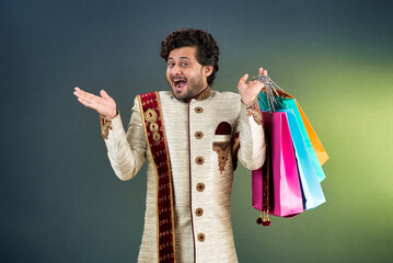Fototapeta premium Indian traditional Young handsome man holding and posing with shopping bags