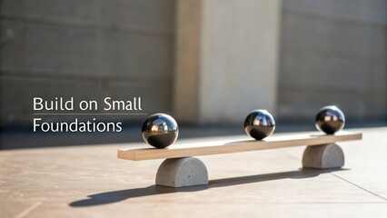 Stylized balancing act with metallic spheres on wooden beam