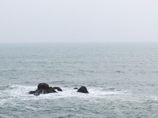 Coastal serenity rocks in the misty ocean. Tranquil seascape nature scene